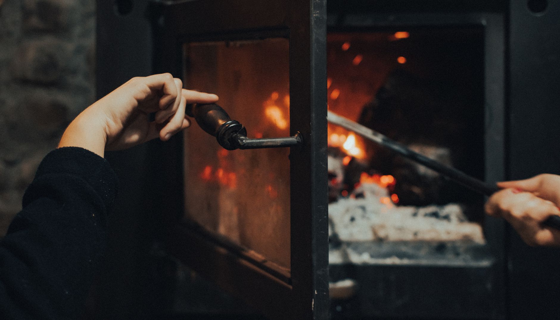 Mains réchauffées devant un poêle à bois allumé